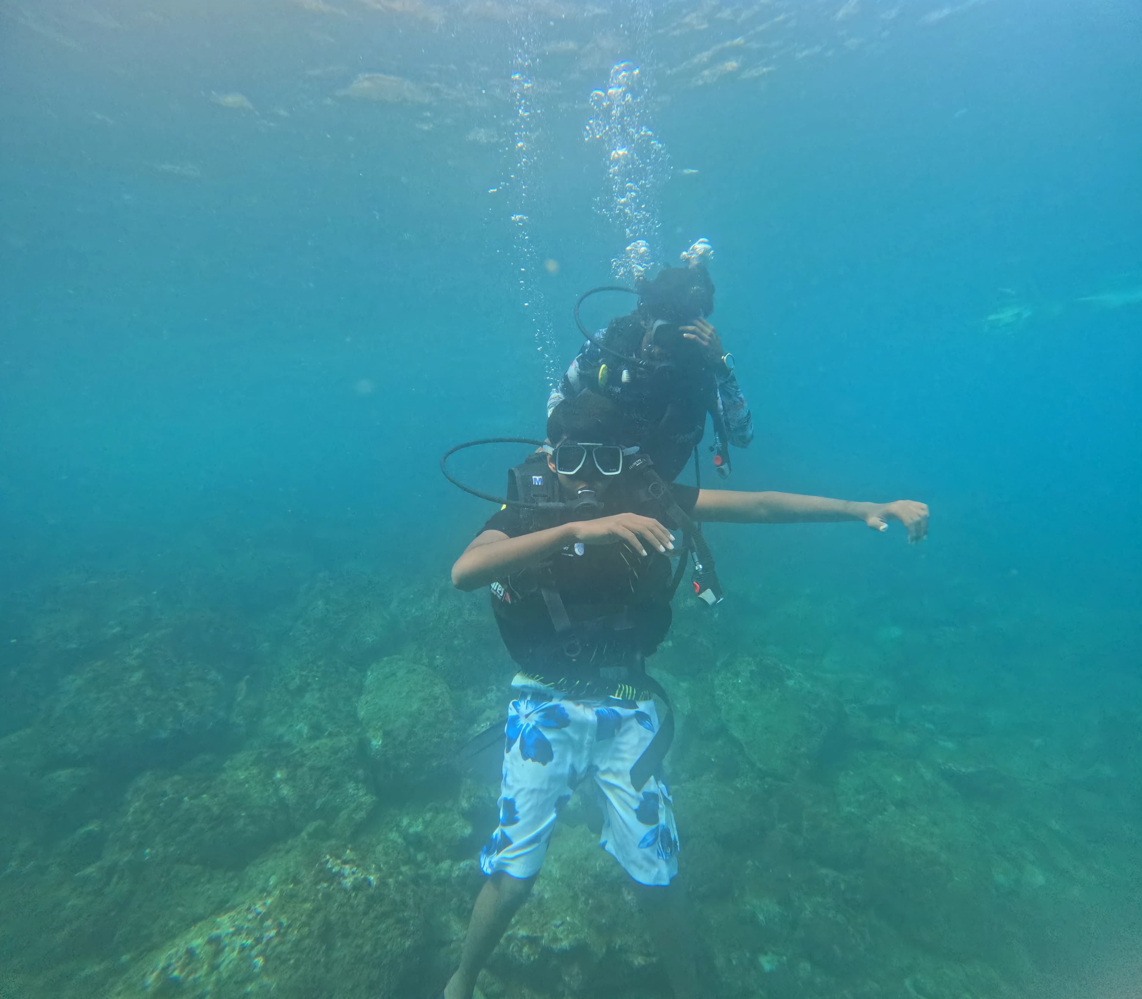 Dive buddies sharing underwater hand signals during a guided dive session